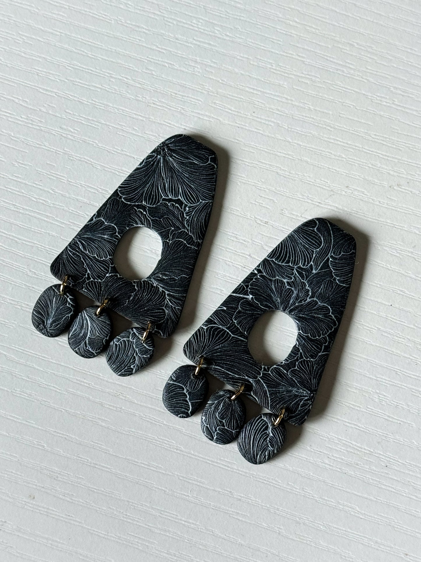 Black textured flower dangle studs
